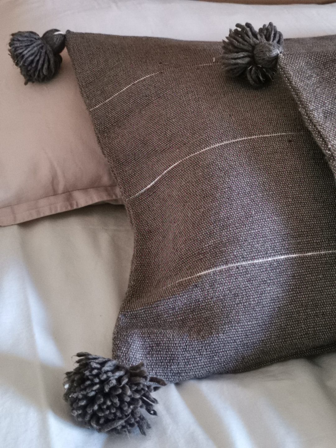 Housse de coussin à pompons gris-taupe